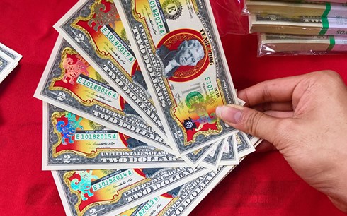 Chi tiền triệu mua 2 USD hình chó mạ vàng biếu Tết