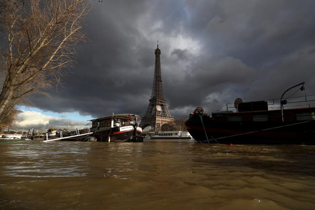 Sông Seine tràn bờ, người Pháp chèo xuồng vượt lụt giữa Paris
