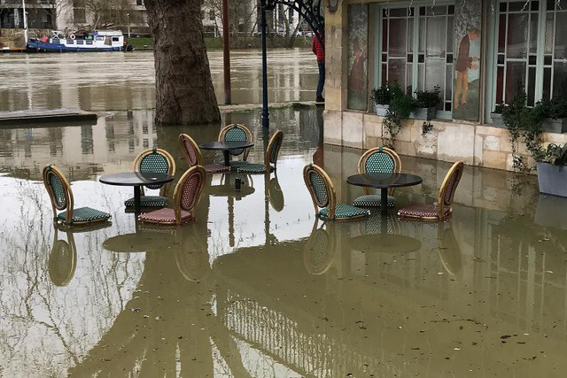 Sông Seine tràn bờ, người Pháp chèo xuồng vượt lụt giữa Paris